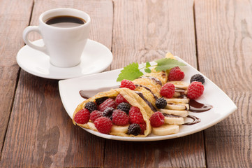 Cup of coffee and pancakes with berries
