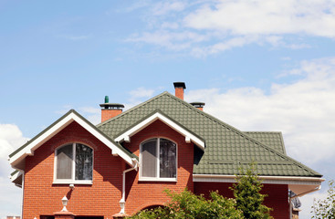 green roof of beautiful house with nice window and blue sky