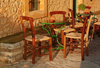 empty table at street village restaurant, Crete, Greece. Sunset