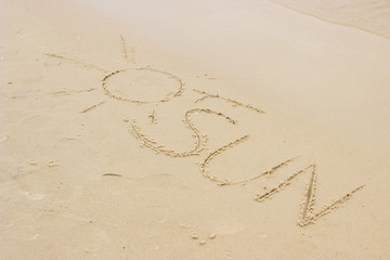 Word sun drawn on sand at the beach by the sea
