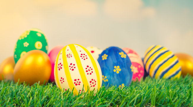 Easter Eggs on Fresh Green Grass over blue sky ( Filtered image