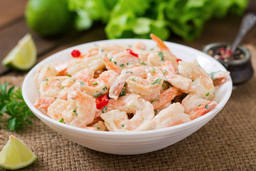 Shrimp in a creamy garlic sauce with parsley and lime in white bowl