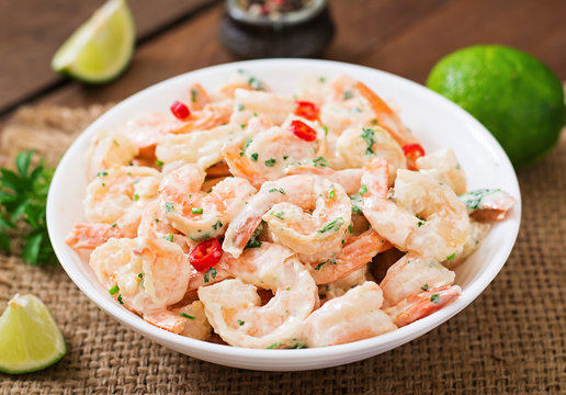 Shrimp In A Creamy Garlic Sauce With Parsley And Lime In White Bowl