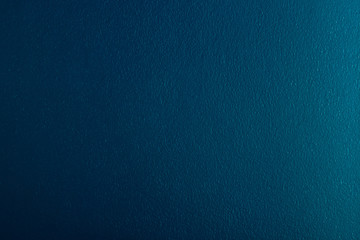 light shines on dark turquoise colored concrete wall