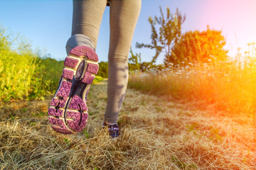 Woman running at sunset in a field