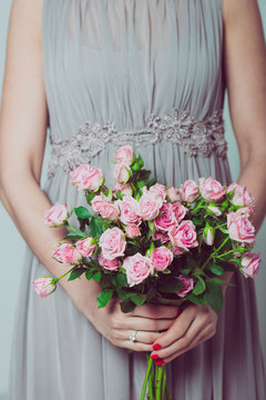 Close up image of bridesmaid with a bouquet of rose flowers