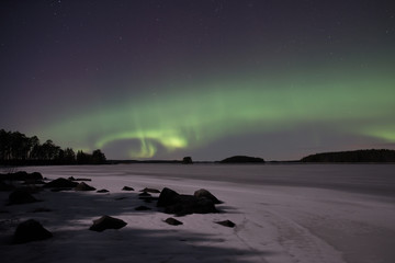 Moonlight lake landscape with northern lights in winter