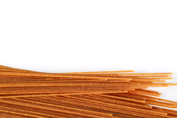 raw whole wheat spaghetti isolated on white background with copy space