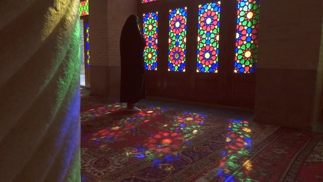 Young Muslim woman praying in Nasir Al-Mulk Mosque (Pink Mosque), Iran, Shiraz