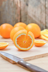 Fresh and juicy half and slice of orange fruit on a chopping blo