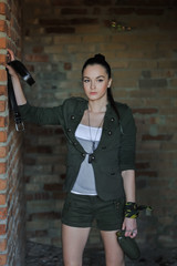 Girl near the brick wall in military style. Lara Croft style.