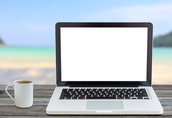 laptop computer and coffee cup front angle on beach view