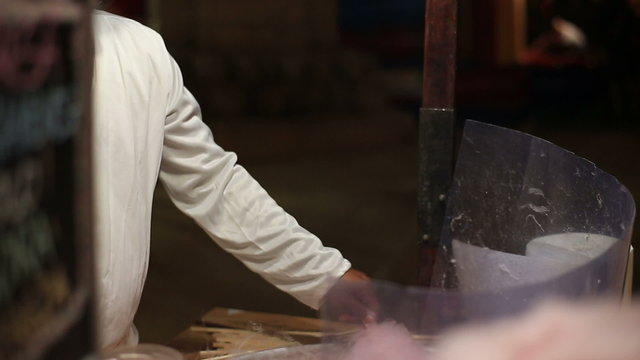 Cotton candy machine creates strands of sugar. Making pink cotton candy in a medieval market.