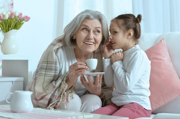 Senior woman with granddaughter with tea