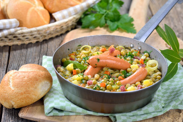 Deftiger Erbseneintopf mit Kartoffeln, Speck und Wiener Würstchen  - Hearty pea stew with...