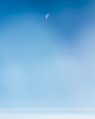 Daytime half Moon in a wispy blue sky