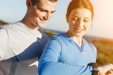 Runner woman with heart rate monitor running on beach