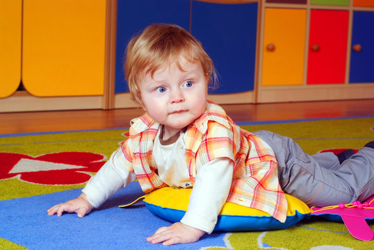 Little boy iying on the carpet
