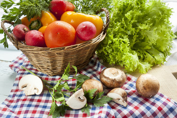 Fresh vegetables covered with water drops in basket. Organic Tomatoes pepper radishes dill parsley mushrooms champignonand vibrant green lettuce from the market.