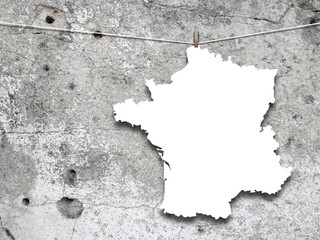 Close-up of one hanged France blank silhouette paper sheet frame against concrete wall background