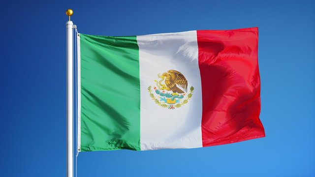 Mexico flag waving in slow motion against clean blue sky, seamlessly looped, close up, isolated on alpha channel with black and white luminance matte, perfect for film, news, digital composition