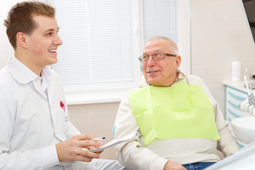 Obraz premium Elderly man on a review of a dentist, sitting in a chair