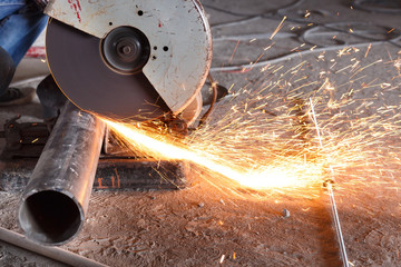 Cutting of a steel with splashes of sparks at construction site.