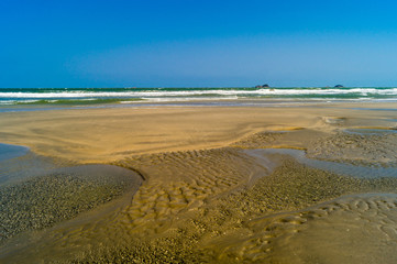 Low tide sand and water .