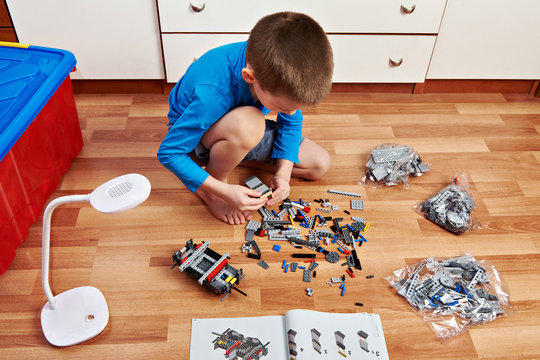 Little boy collects plastic constructor