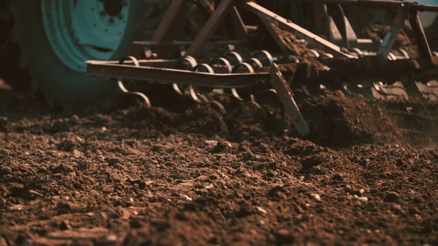Tractor plowing field at sunset