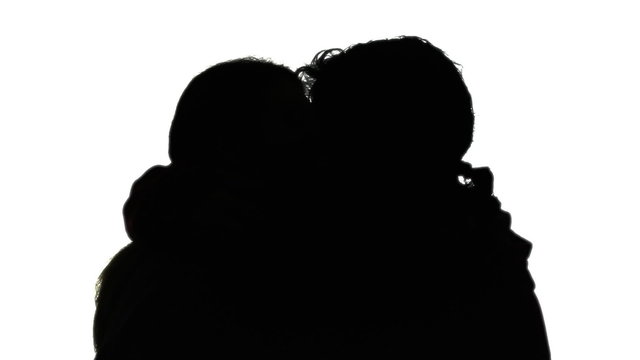 A man and a woman intensely kissing, touching each other with passion (foreplay). Silhouette shot. Love, lovers, Valentine.