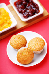 Muffins and jam on a red background