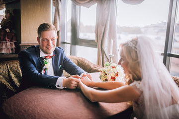 Happy bride and groom in royal vintage interior of restaurant