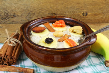 Oatmeal porridge in bowl topping with banana cinnamon dry fruits