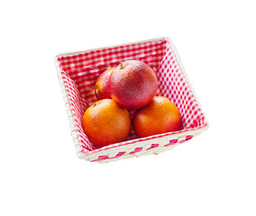 Bunch of red sicilian red oranges in basket isolated on white