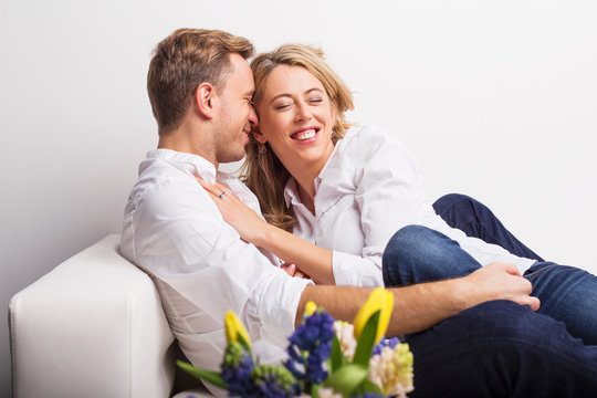 Happy couple cuddling on couch