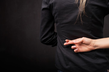 Fingers crossed behind back