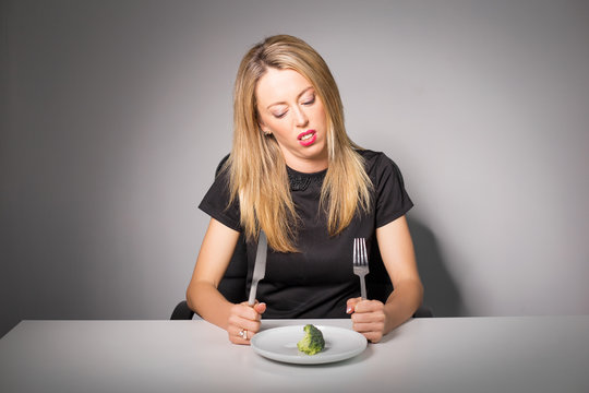 Woman on diet eating broccoli