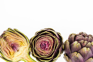 Obraz premium Three fresh purple artichokes, on white background with copy-space