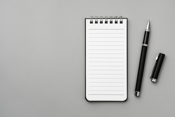 Notebook and pen on gray board background