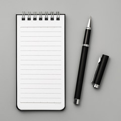 Notebook and pen on gray board background