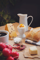 Continental breakfast with black coffee and milk on old wooden table