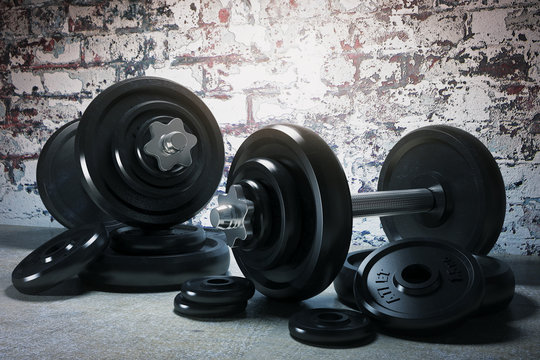 Two dumbbells on brick wall