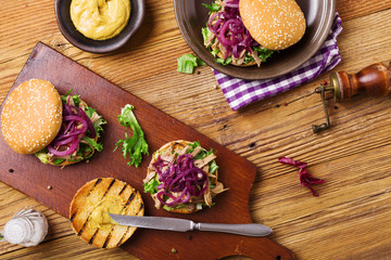 Fototapeta premium Burger with meat of duck with red onion and lettuce.