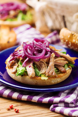 Burger with meat of duck with red onion and lettuce.