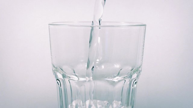 Sparkling Water Pours Into Rotating Glass