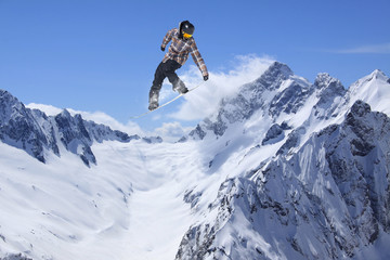 Fototapeta na wymiar Snowboarder jumping on mountains. Extreme sport.