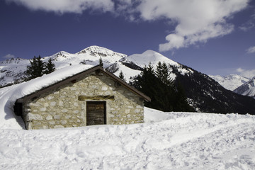 mountain panorama with hut covered in snow