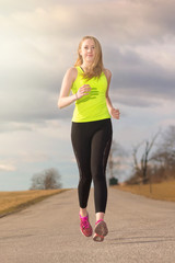 Fit young woman running at a country road