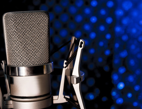 Silver microphone on black and blue background
